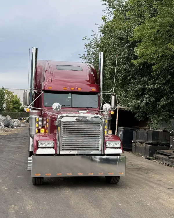 Truck driver beside a heavy duty fleet rig at a depot